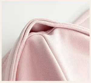 Close-up of the mask's soft pink fabric, curved layers, and neatly stitched bound edge
