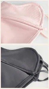 Close-up of pink and dark gray fleece face coverings, showing stitched edges and soft tie straps