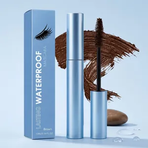 Waterproof brown mascara tube and box on a blue backdrop, with a brown swatch, water drops and stone