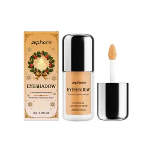 Goldener flüssiger Lidschatten mit Schimmer, neben Applikator und festlicher Verpackung