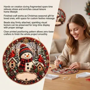 Close-up van een fonkelende kerstdecoratie met sneeuwpop, naast een vrouw die diamond painting maakt