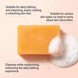 Close-up of an orange translucent soap bar with fine texture, white foam and water droplets