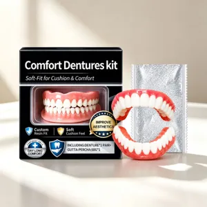Display of a black comfort denture kit box, a red-and-white denture pair, and a silver sachet