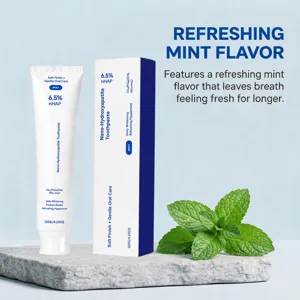 Mint toothpaste tube and box beside fresh mint leaves on a stone platform against pale blue