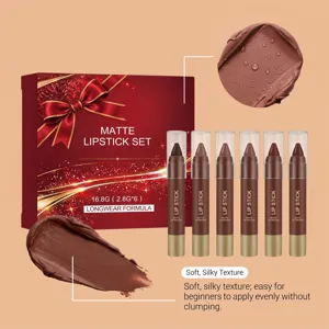 Red gift box with gold ribbon beside six brown lipstick pencils and matte texture swatches