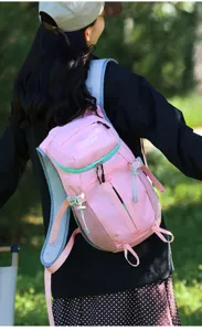Rear view of a person wearing a pink backpack with mint trim in a forest setting in natural light