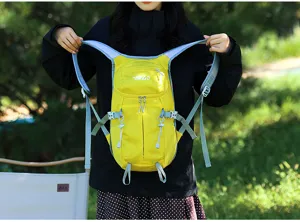 Yellow outdoor backpack with pale blue straps and front zip pockets, held up by a model outdoors