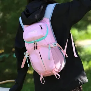 Pink lightweight outdoor hiking backpack with mint green zippers, shown worn against a forest backdrop