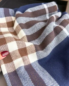 Vue rapprochée du tissu épais à carreaux plissé en bleu marine, brun, crème et gris bleuté