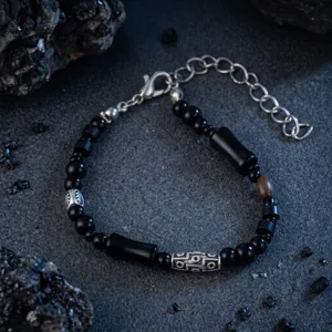Bracciale di perline nere con dettagli argentati, perla in legno e chiusura a catena regolabile