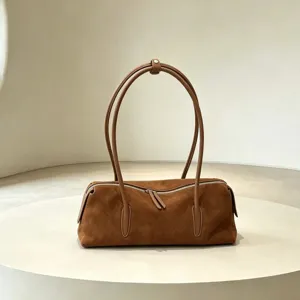 Brown suede-textured handbag displayed upright, highlighting its twin handles and silver zipper