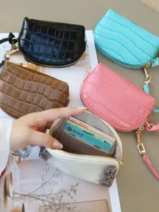 Close-up of crocodile-embossed pouches in assorted colors, with gold zippers and cards inside