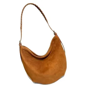 Sac d’épaule en suède brun, forme demi-lune, avec anse tressée et détails métalliques argentés