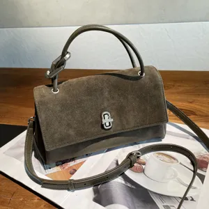 Close-up view of the olive suede-textured flap, silver clasp, top handle and adjustable strap