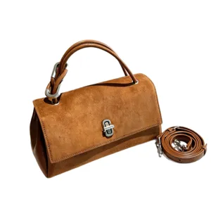 Brown suede-texture handbag with silver clasp, top handle and detachable shoulder strap, angled view