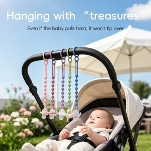 Five colorful silicone bead pacifier clips hang from a stroller handle beside a seated baby