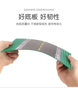 Hands bend a green studded building baseplate with a printed road, showing its flexible surface