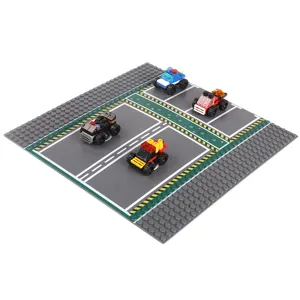 Building block road baseplate set with marked gray streets and toy cars, shown from an angled top view