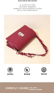 Borsa in pelle rossa con chiusura argentata e tracolla intrecciata, esposta su uno sfondo beige