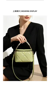 Model wearing a green quilted bag with pearl handle and gold chain hardware against a white backdrop