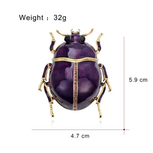 Close-up of a purple enamel beetle with antique-gold trim, pink stones and black rhinestone eyes