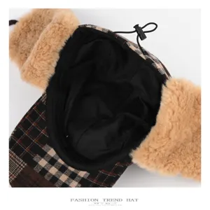Close-up of the black lining, plaid wool fabric, and adjustable drawcord on a winter trapper hat