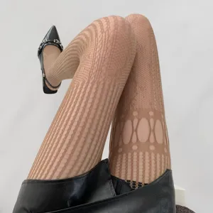 Close-up of crossed legs in nude fishnet tights with patterned openwork texture and black heels