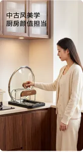 A woman places a glass pot lid on a metal kitchen rack with a wooden handle on the countertop