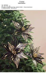 Trois fleurs de Noël en tissu noir et or, aux centres pailletés, sur des branches de sapin vertes