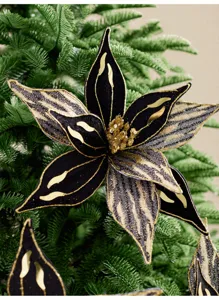 Gros plan sur une fleur de Noël en velours noir, bordure dorée, paillettes et centre perlé