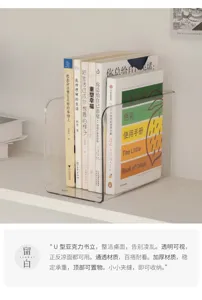 Clear U-shaped acrylic holder on a white desk, keeping books upright between transparent sides