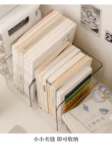 Clear divided desk organizer holding books upright beside stationery in a bright study setting