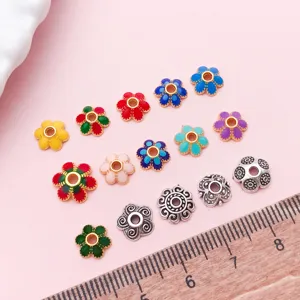 Vue de dessus de coupelles florales émaillées colorées et d’intercalaires argentés ornés