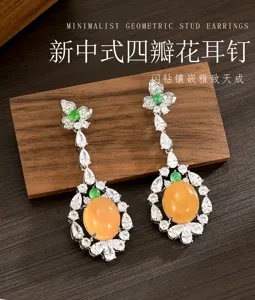 Par de pendientes colgantes con cabujones naranjas, circonitas claras, detalles verdes y flores