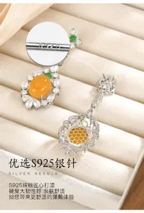 Primer plano de piedras naranjas con detalles claros, cuentas verdes y diseño calado plateado en panal