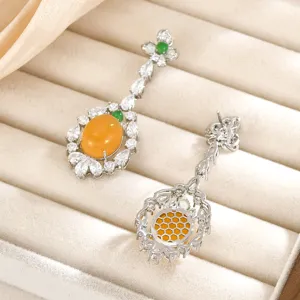 Pendientes largos de trébol con cabujones naranjas, detalles verdes y brillantes circonitas
