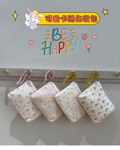 Quatre petites pochettes fleuries à zip et dragonnes tressées, suspendues côte à côte