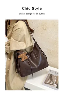 Side view of a brown faux-leather bag worn crossbody, with stitched panels and a teddy bear charm