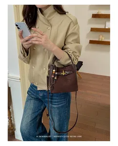 Lifestyle view of a dark brown bag with beaded tassel and metal buckle, worn crossbody