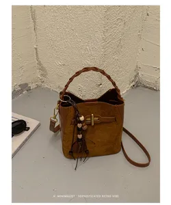 Brown suede-textured surface, braided handle, adjustable strap and wooden heart charm on display