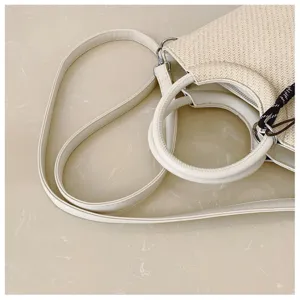 Détail d’un sac tressé ivoire avec anse, bandoulière réglable et bouclerie argentée