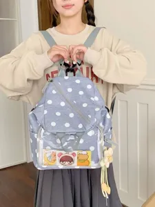 Sac à dos gris à pois blancs, poche transparente et breloque fleur, présenté de face