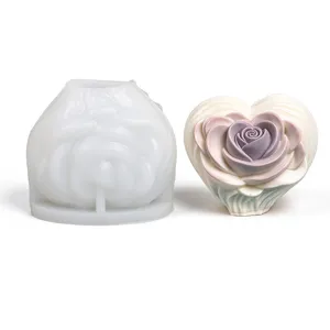 White silicone heart mold beside a finished rose-shaped candle in ivory and pale lavender tones