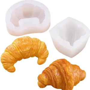 Translucent silicone croissant mold with golden, layered croissant-shaped handmade pieces