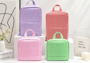 Four striped fabric bags with zipper closures and handles in purple, red, pink and green on display