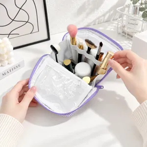 Open cosmetic bag showing a white divided interior, clear zip pocket, and makeup tools