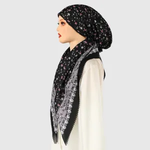 Vista laterale di un manichino con foulard nero a fiori e bordo decorativo in pizzo grigio