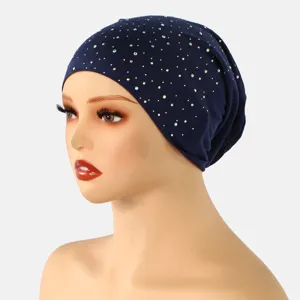 Zijaanzicht van een marineblauwe gebreide kap met zilveren strassteentjes op een mannequin