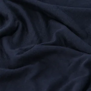 Primo piano del tessuto a maglia blu navy scuro, con trama fine e morbide pieghe naturali