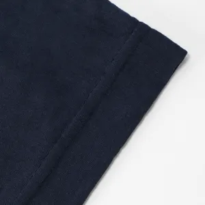 Primo piano del tessuto a maglia blu navy, con trama fine, cucitura e bordo ripiegato